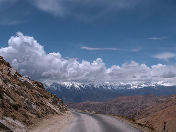 Road leading towards mountains against sky