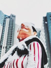 Portrait of man with snow on building during winter