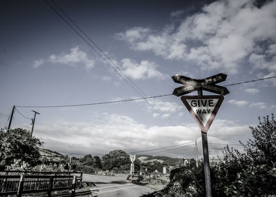 Low angle view of road sign against sky