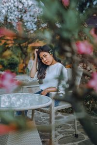 Portrait of smiling young woman against plants