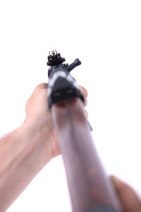 Close-up of man holding cigarette over white background