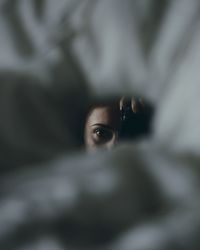 Portrait of young woman holding camera indoors