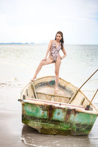 Full length portrait of young woman on beach