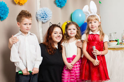 Siblings standing against wall