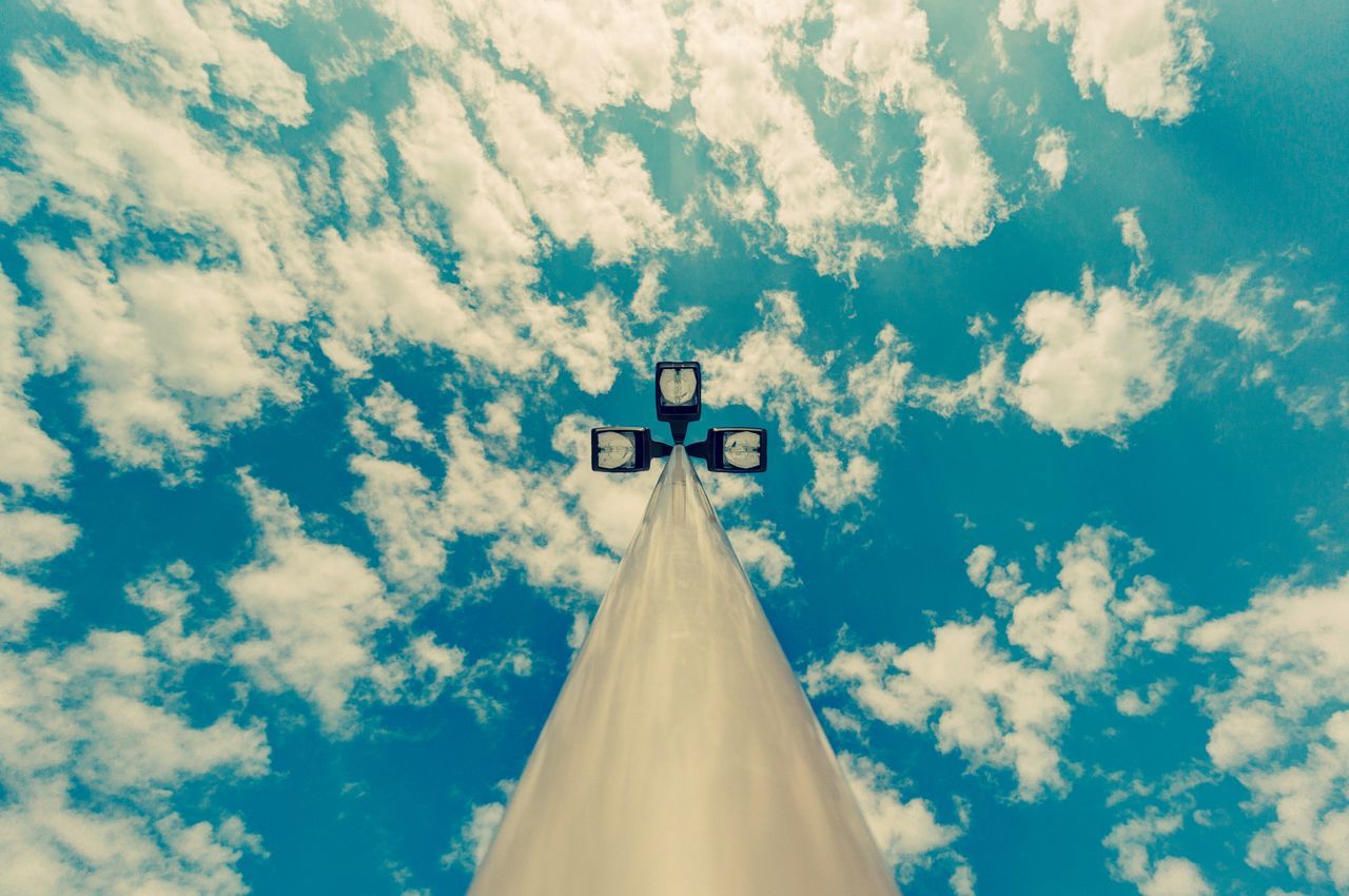 low angle view, sky, blue, cloud - sky, airplane, transportation, cross, cloud, travel, religion, day, air vehicle, mode of transport, outdoors, no people, built structure, spirituality, high section, part of