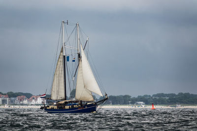 Sailboat sailing on sea against sky