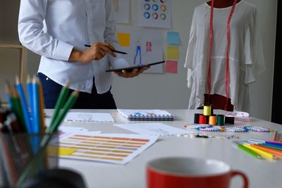 Midsection of fashion designer working in office