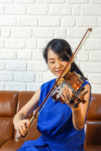 Woman playing violin at home