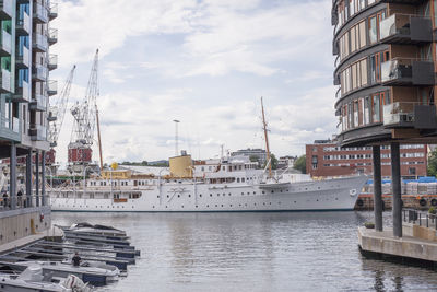 Ship moored in oslo harbor by buildings in city against sky.