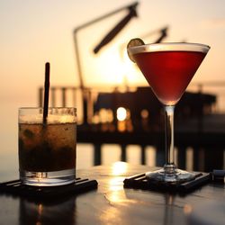 Close-up of drink on table against sky during sunset