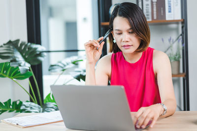 Young woman using phone on table