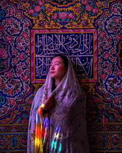 Woman standing against multi colored wall