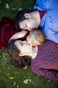 Young couple kissing daughter on grass in detroit mi