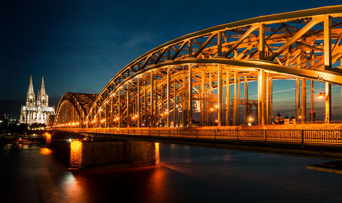 View of bridge over river in illuminated city at night