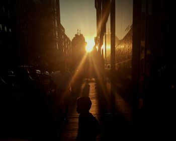 People walking on city street during sunset