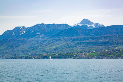 Scenic view of sea and mountains against sky