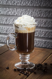 Close-up of coffee with whipped cream on wooden table