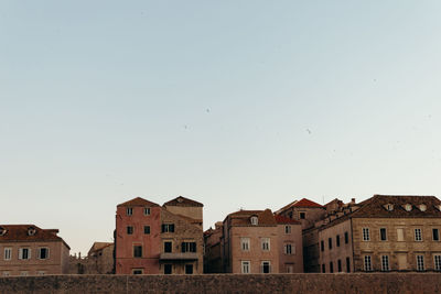 Low angle view of buildings in town against clear sky