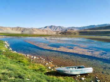 Scenic view of lake and mountains against clear blue sky