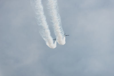 Low angle view of airplanes flying against sky during air show