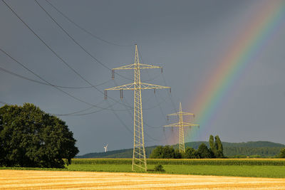 Low angle view of rainbow over field against sky