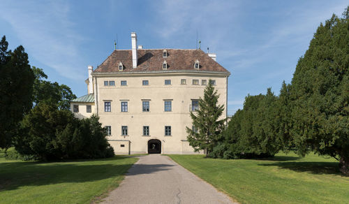 Building by trees against sky