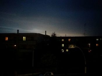 Illuminated buildings against sky at sunset