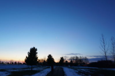 Snow covered landscape against blue sky