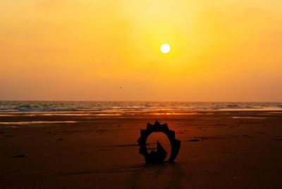 Silhouette men on beach against sky during sunset