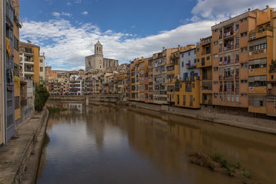 Canal amidst buildings in city, , girona spain