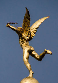 Low angle view of statue against blue sky