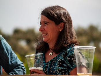 Portrait of a smiling young woman drinking glass