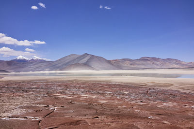 Scenic view of mountains and salt flat against blue sky