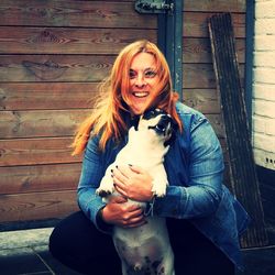 Portrait of a smiling young woman holding dog