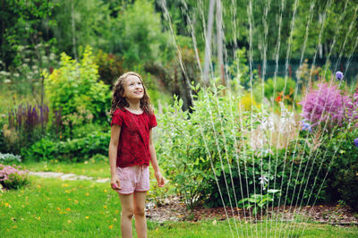 Full length of a smiling girl standing in grass