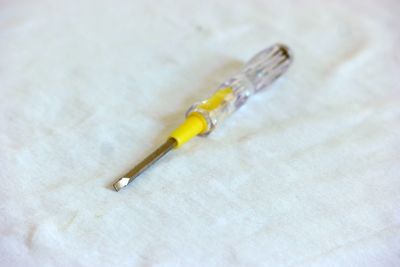 Close-up of screwdriver on white fabric