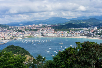 High angle view of townscape by sea against sky