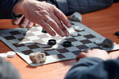 Cropped image of man playing jigsaw puzzle