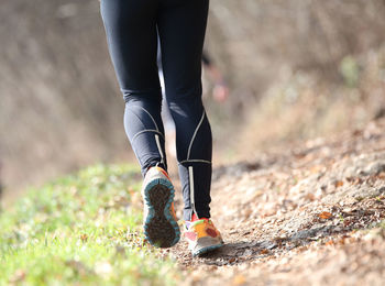 Low section of woman wearing shoes on field