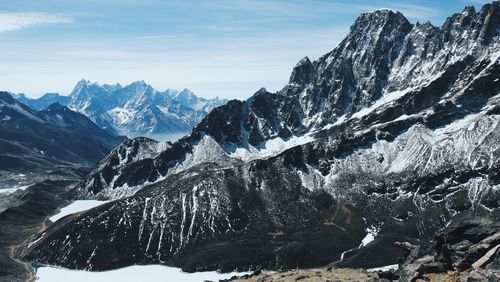 Scenic view of snowcapped mountains against sky on sunny day