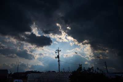 Low angle view of silhouette electricity pylon against sky during sunset