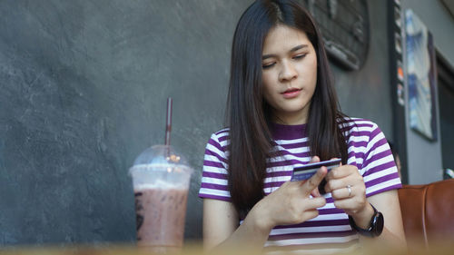 Young woman looking down while sitting on table