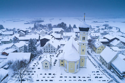 High angle view of snow covered houses and buildings against sky