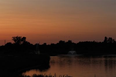 Scenic view of lake against orange sky