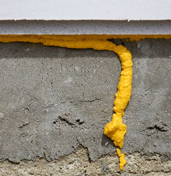 Close-up of yellow shoes hanging on wall