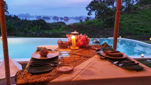 High angle view of breakfast on table by swimming pool against lake