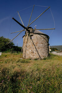 Traditional windmill on field against sky