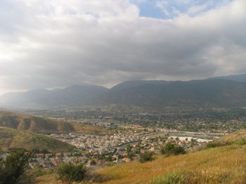 View of cityscape against cloudy sky