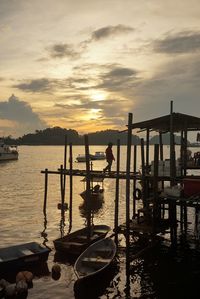 Boats in sea at sunset