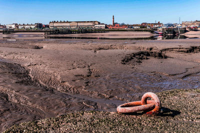 Rusty metal on beach against clear sky